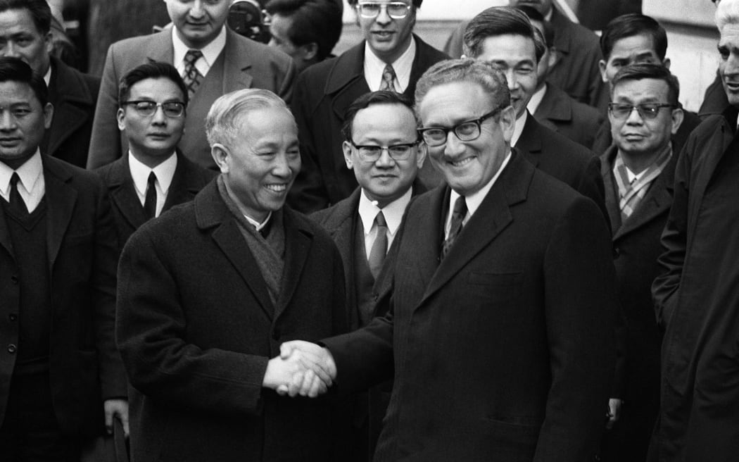(FILES) US National Security Advisor Henry Kissinger (R) shakes hand with Le Duc Tho, leader of North-vietnamess delegation, after the signing of a ceasefire agreement in Vietnam war, 23 January in Paris. Former US secretary of state Henry Kissinger, a key figure of American diplomacy in the post-World War II era, died November 29, 2023 at the age of 100, his association said. (Photo by AFP)