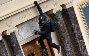 A protester supporting US President Donald Trump jumps from the public gallery to the floor of the Senate chamber at the U.S. Capitol Building on January 06, 2021 in Washington, DC.