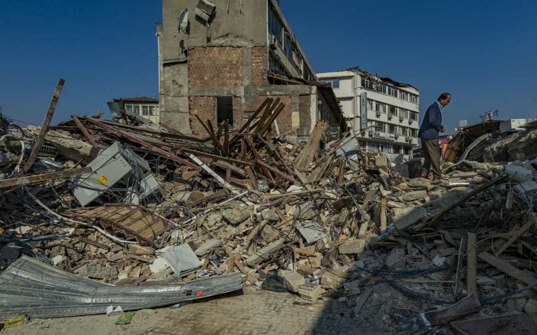 A man walks in the ruins of the city center of Antakya, destroyed after the massive earthquake in southern Turkey. (Photo by Celestino Arce/NurPhoto) (Photo by Celestino Arce / NurPhoto / NurPhoto via AFP)