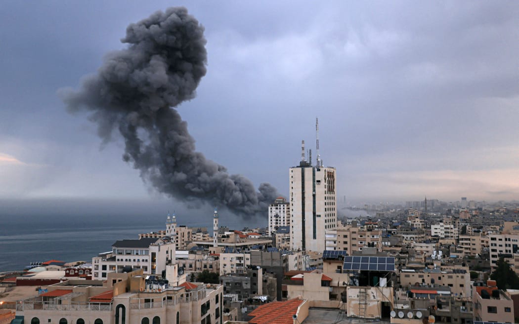 Smoke rises above buildings during an Israeli air strike, in Gaza City on October 9, 2023. Israeli troops fought to regain control of the desert around the Gaza Strip and evacuate people from the embattled border area on October 9, 2023, as the death toll from the war with Hamas surged above 1,100 by the third day of clashes. (Photo by MAHMUD HAMS / AFP)