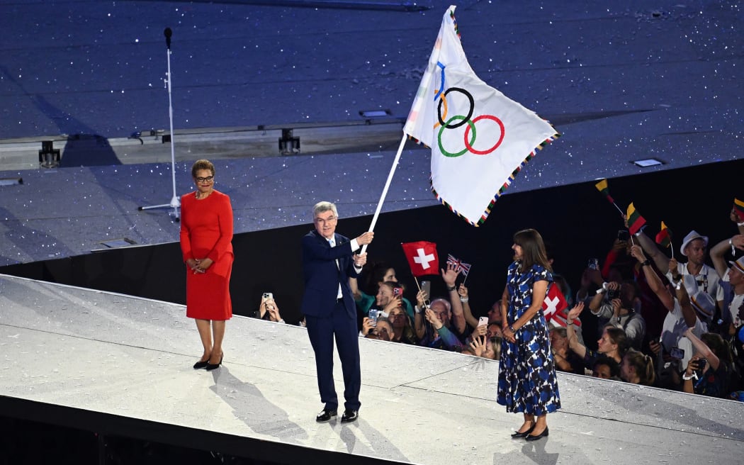 IOC President Thomas Bach hands the Olympic Flag from Paris to Los Angeles during the Closing Ceremony of the 2024 Paris Olympic Games at Stade de France.