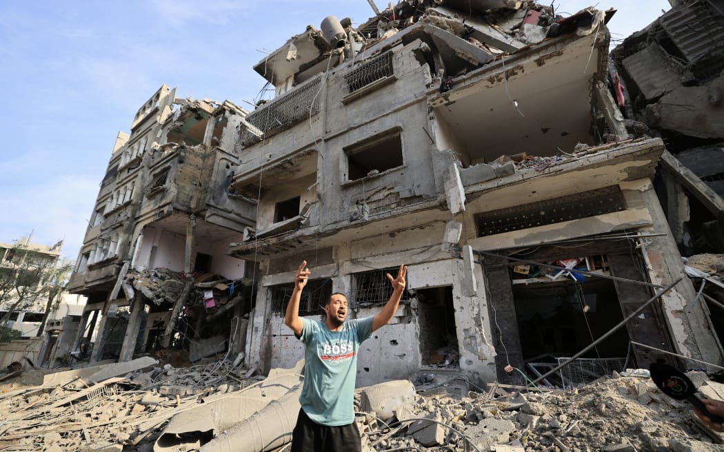 A Palestinian man reacts as he stands amid the destruction in the aftermath of Israeli bombardment in al-Karama district in Gaza City on October 11, 2023. The death toll from five days of ferocious fighting between Hamas and Israel rose sharply overnight as Israel kept up its bombardment of Gaza after recovering the dead from the last communities near the border where Palestinian militants had been holed up. (Photo by Mahmud HAMS / AFP)