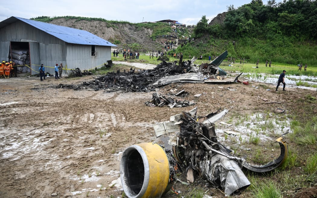 Rescuers work at the site after a Saurya Airlines' plane crashed during takeoff at Tribhuvan International Airport in Kathmandu on July 24, 2024. A passenger plane crashed on takeoff in Kathmandu on July 24, with the pilot rescued from the flaming wreckage but all 18 others aboard killed, police in the Nepali capital told AFP.