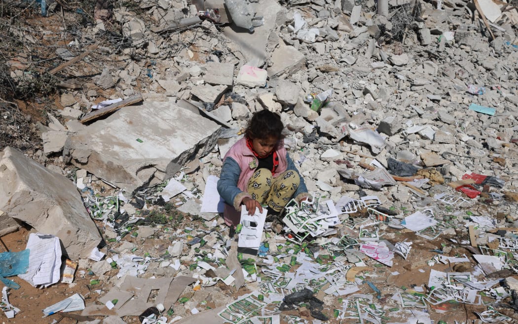 A Palestinian girl looks for salvageable items amid the destruction on the southern outskirts of Khan Yunis in the war-battered Gaza Strip on January 16, 2024, amid continuing fighting between Israel and the Palestinian militant group Hamas.