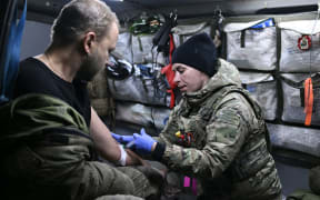 A Ukrainian medic treats a wounded serviceman in a medical evacuation car in the Donetsk region on 30 November, 2023, amid the Russian invasion of Ukraine.