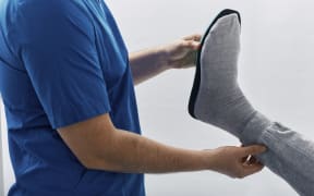 Orthopedist fitting orthopedic insole. (Photo by PEAKSTOCK / SCIENCE PHOTO LIBRAR / LDA / Science Photo Library via AFP)