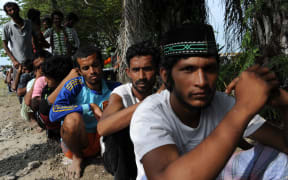 Migrants from Bangladesh line up to be documented by Indonesian immigration personnel Langsa in Aceh province.