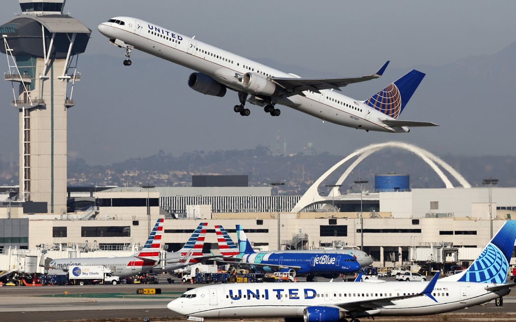 A United Airlines plane takes off as another taxis at Los Angeles International Airport (LAX) following the Thanksgiving holiday on 2 December, 2024.