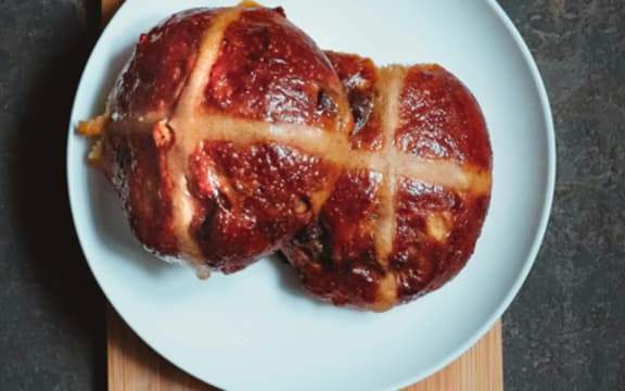 A hot cross bun on a plate