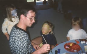 Peter Ellis painting faces at the Christchurch Civic Creche. The children's faces have been blurred.