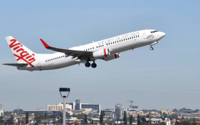 A Virgin Australia plane takes off at Sydney Airport in Sydney on March 19, 2020. -