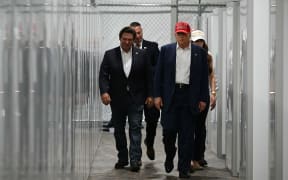 Florida Governor Ron DeSantis (L), US President President Donald Trump (C) and Homeland Security Secretary Kristi Noem (R) tour a medical facility during a visit to a migrant detention center, dubbed "Alligator Alcatraz," located at the site of the Dade-Collier Training and Transition Airport in Ochopee, Florida on July 1, 2025. President Trump is visiting a migrant detention center in a reptile-infested Florida swamp dubbed "Alligator Alcatraz." Trump will attend the opening of the 5,000-bed facility -- located at an abandoned airfield in the Everglades wetlands -- part of his expansion of deportations of undocumented migrants, his spokeswoman said. (Photo by ANDREW CABALLERO-REYNOLDS / AFP)