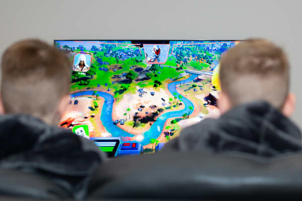 Children playing Fornite on a large screen.