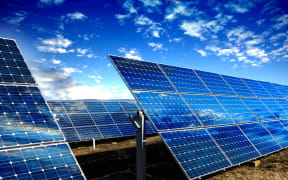Rows of photovoltaic solar panels and blue sky with clouds