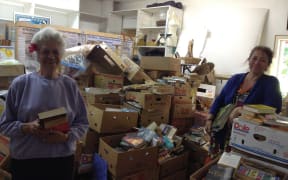 Jean Mason (right), the manager and curator of the Cook Islands Library and Museum Society, and librarian Sally Voss with donated books delivered recently by a Royal New Zealand Air Force C-130 Hercules aircraft.