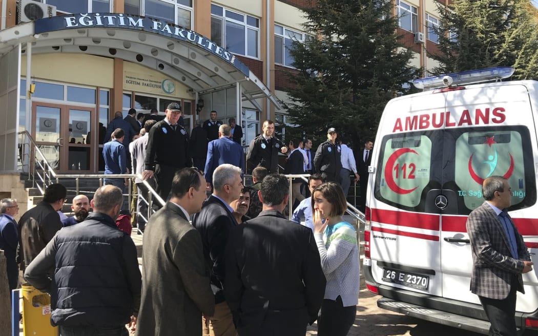 People are seen near an ambulance in front of an education faculty after a research assistant shot dead four staffers of Osmangazi University and injured three others in Eskisehir province of Turkey on April 05, 2018.
