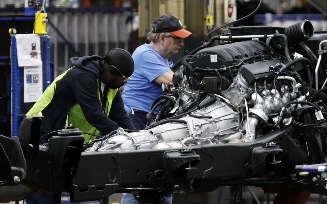 (FILES) In this file photo taken on June 12, 2019 Line workers assemble the chassis of full-size General Motors pickup trucks at the Flint Assembly plant in Flint, Michigan. -