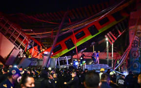 Rescue workers gather at the site of a metro train accident after an overpass for a metro partially collapsed in Mexico City.
