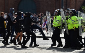 Police officers face protesters outside the Liver Building in Liverpool on 3 August, 2024 during the 'Enough is Enough' demonstration held in reaction to the fatal stabbings in Southport on 29 July. UK police prepared for planned far-right protests and other demonstrations this weekend, after two nights of unrest in several English towns and cities.