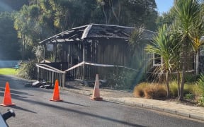 A wooden building damaged by fire.