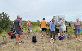 Club members take part in a watering day, carrying buckets of water to each of the new trees planted throughout the dunes.