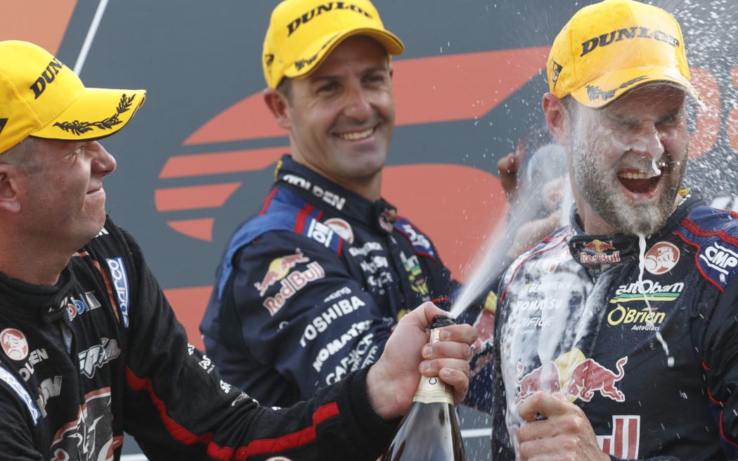 Shane van Gisbergen cops a faceful of champagne on the podium.