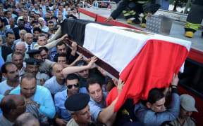 People carry the coffin of Egyptian police officer Mohamed Wahid, killed a day earlier in a shoot-out with suspected militants southwest of Cairo.