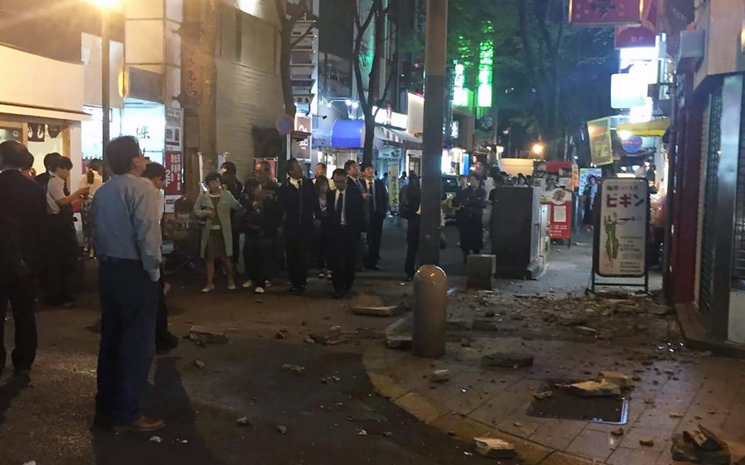 Residents stand on the street following an earthquake in Kumamoto city on April 14, 2016.