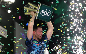 Luke Humphries celebrates with the Sid Waddell Trophy after winning the World Darts Championship final, January 2024.