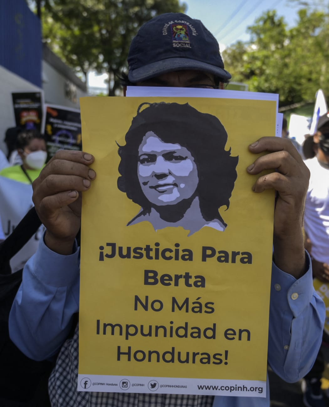 A demonstrator holds a poster with an image of slain Honduran environmental activist Berta Caceres as members of environmental organizations and university students protest in San Salvador on March 22, 2022.