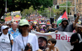 Protesters take part in the annual "Invasion Day" rally, organised on Australia Day, in Sydney on January 26, 2026. (Photo by Steven Markham / AFP)