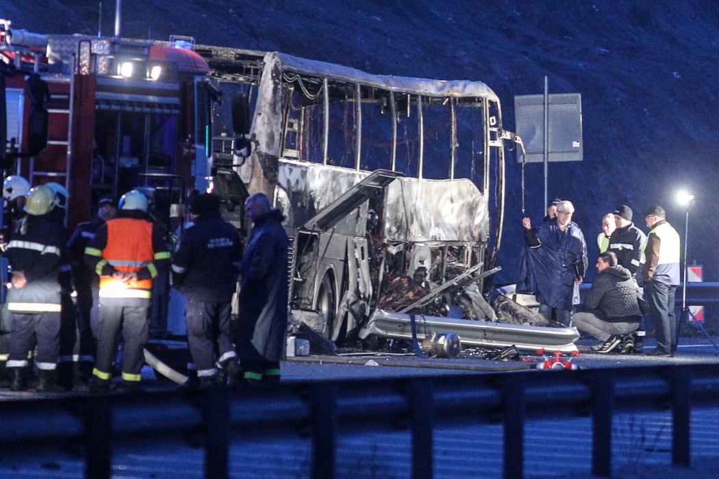 Officials work at the site of a bus accident, in which at least 45 people were killed, on a highway near the village of Bosnek, south of Sofia, on November 23, 2021.