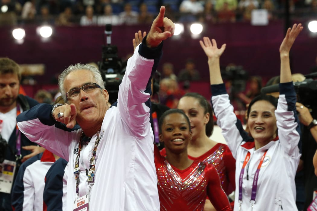 US women gymnastics team's coach John Geddert celebrates with the rest of the team after the US  won gold in the women's team artistic gymnastics event at the London Olympic Games.