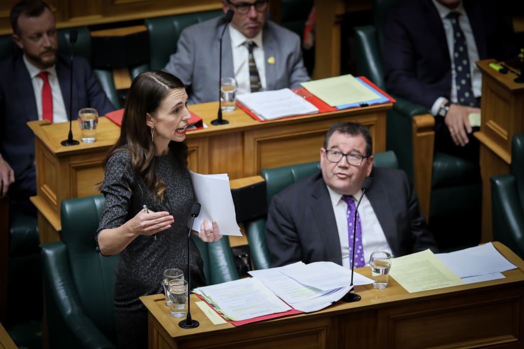 Grant Robertson listens to Jacinda Ardern answer questions in the House