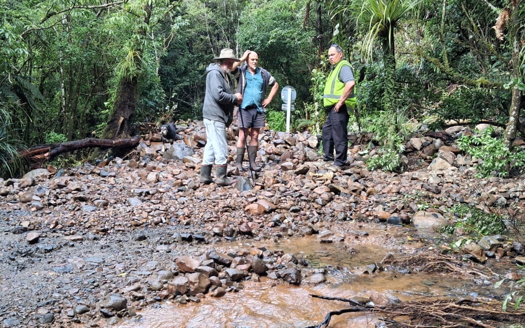 Max Osborne (left) had to walk and hitchhike to the nearest town for supplies after being trapped in his home for days. The Wekaweka Road bridge is buried somewhere under those rocks.