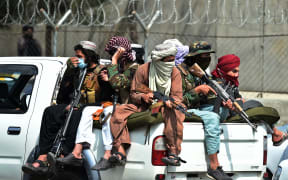 Taliban fighters guard outside the airport in Kabul on August 31, 2021