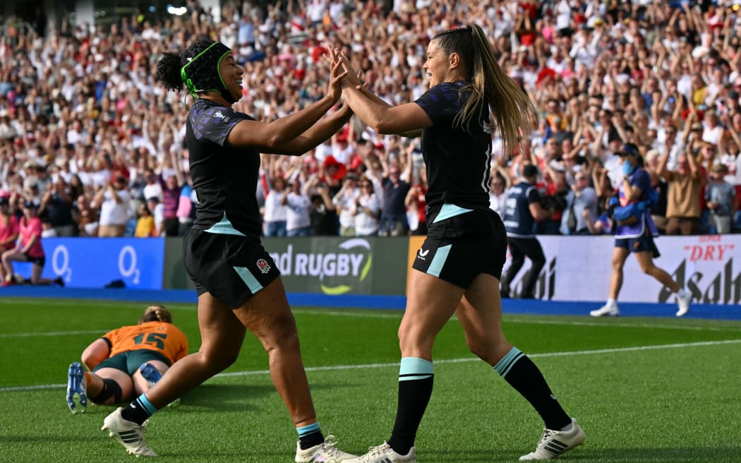 England's wing Jess Breach (R) celebrates after scoring their first try during the Women’s Rugby World Cup pool A match between England and Australia at Brighton & Hove Albion Stadium, Brighton, southeast England, on September 6, 2025. (Photo by Glyn KIRK / AFP)