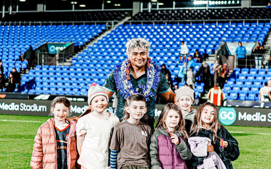 Moana Pasifika number Lotu Inise with young fans at Mount Smart Stadium in Auckland on Friday night. Photo: Moana Pasifika