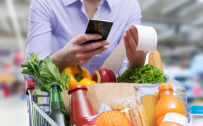 Woman checking the grocery receipt using her smartphone