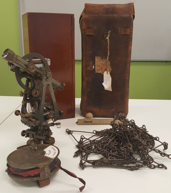 A Vernier theodolite, and several different types of surveyor's chain. The Gunter's chain, to the right, is comprised of a 100 links.