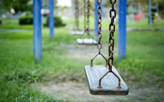 An empty swing at a children's playground