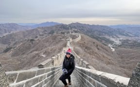 Chen Liu standing on the Mutianyu section of the Great Wall of China. It is a clear, cold day.