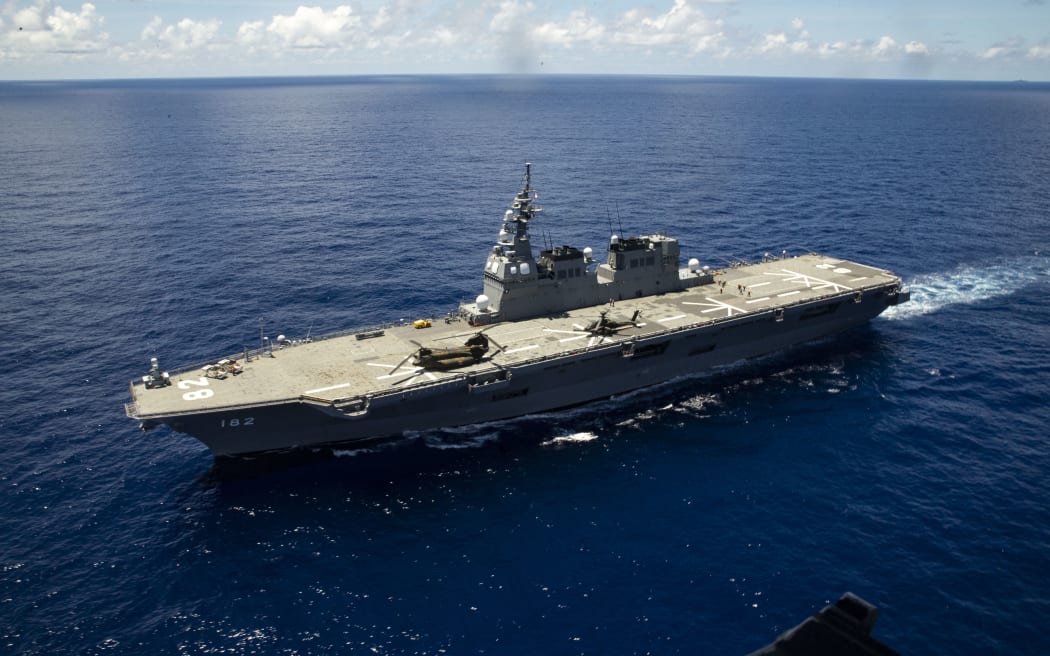 JS Ise sails in the Philippine Sea as an MV-22 Osprey conducts touch-and-go flight training in the Philippine Sea, August 24, 2021.