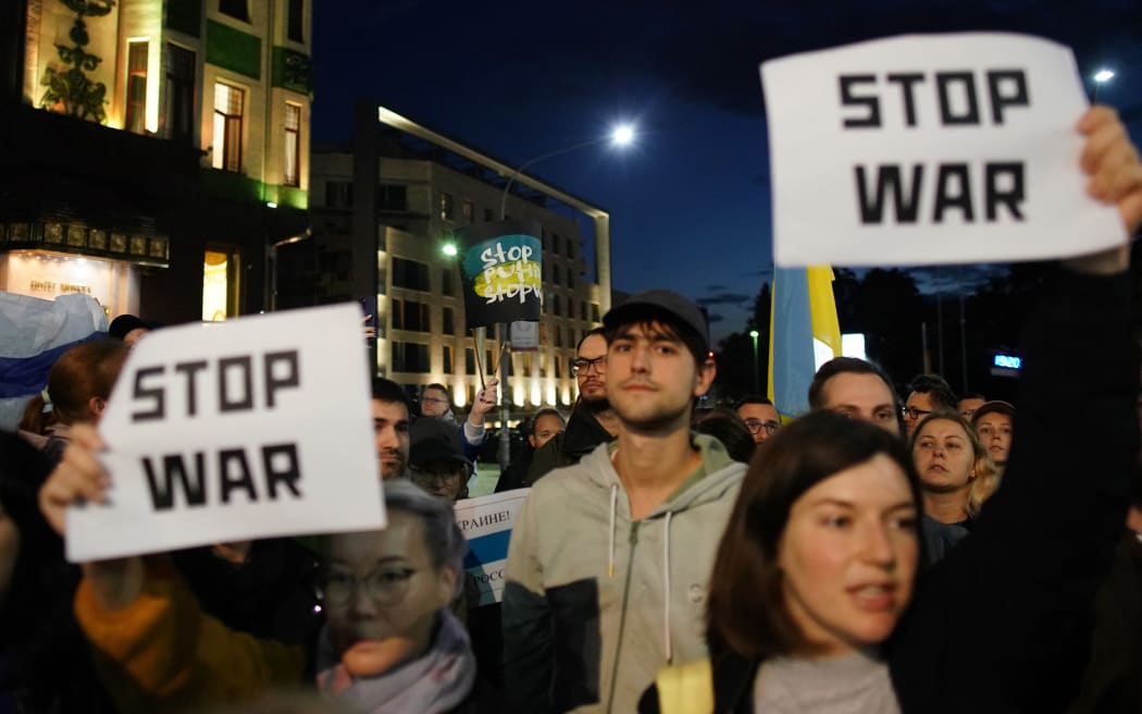 People hold anti-war banners during a protest in Belgrade on September 21, 2022, after Russia President dramatically escalated his seven-month war in Ukraine by calling up 300,000 military reservists. (Photo by OLIVER BUNIC / AFP)