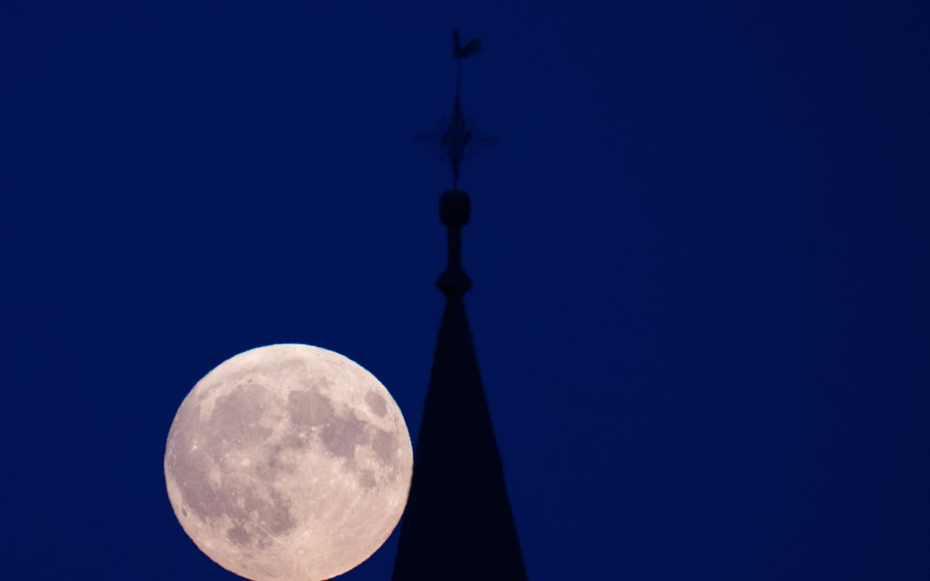 The "supermoon" rises behind the church in Wehrheim in the Hessian Taunus 17 September 2024.  Due to its relatively close proximity to the earth, the moon appears particularly large.