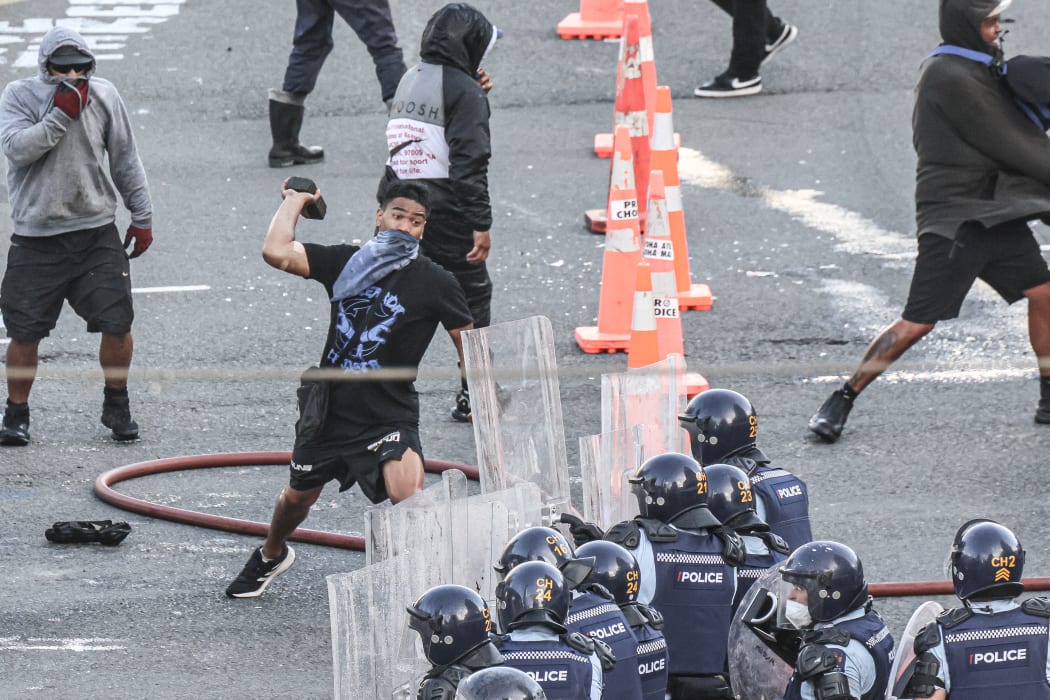 A paving stone is thrown at police on the Bowen/Lambton corner