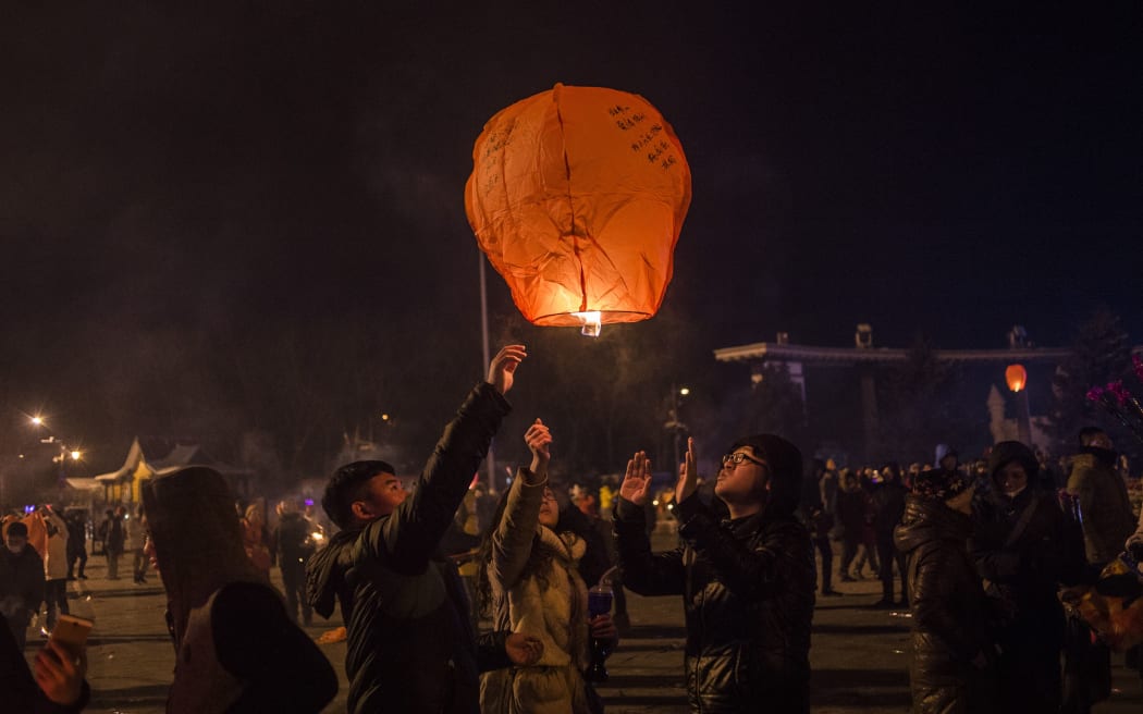 People release a sky lantern to celebrate the New Year in Harbin, China.