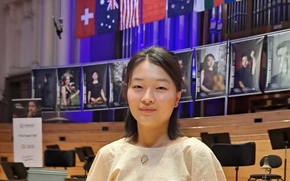 Violinist Yeyeong (Jenny) Jin stands onstage at the Auckland Town Hall