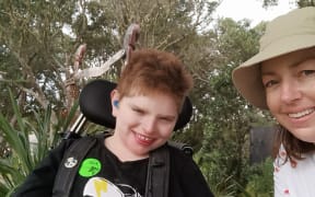 Kylee Ostermann (right) and her 11-year-old son Alex (left) have waited nearly a year for specialist equipment to allow him to stand upright.