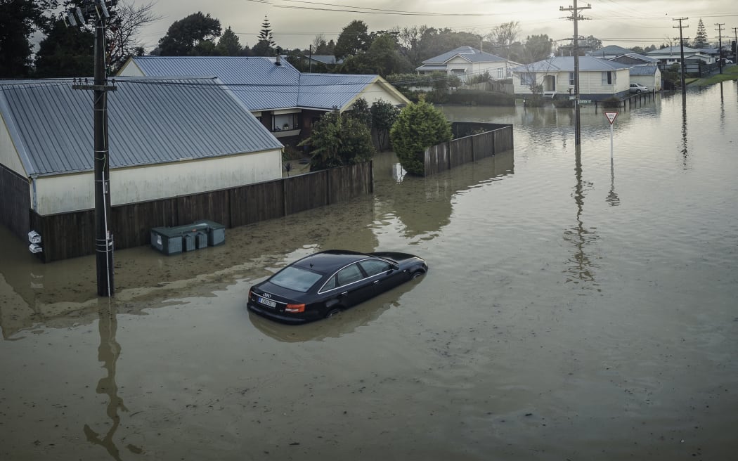 A partly-submerged car outside flooded houses on Disraeli St, Westport.